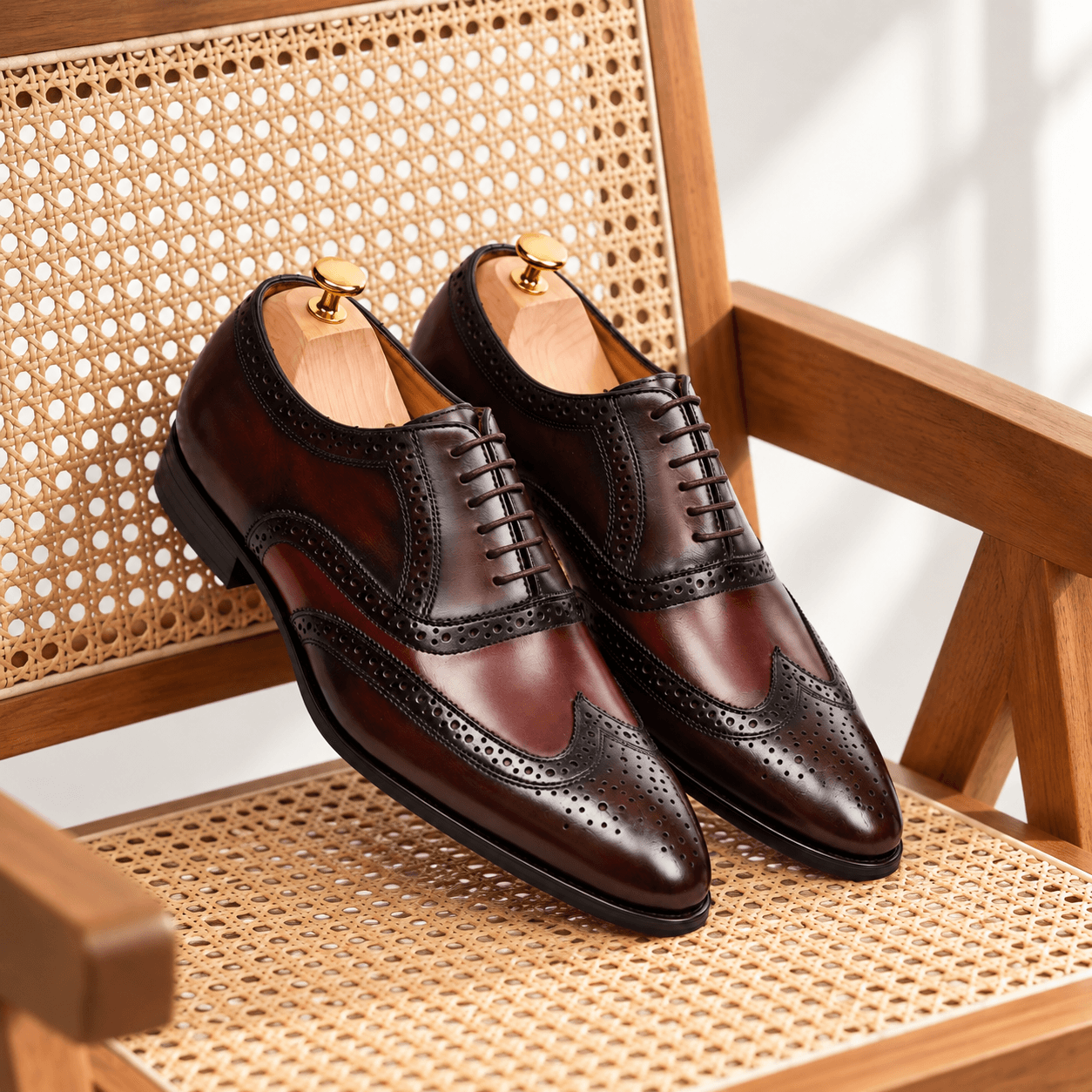 Gomilla leather brogues styled on a rattan chair, lifestyle product photo